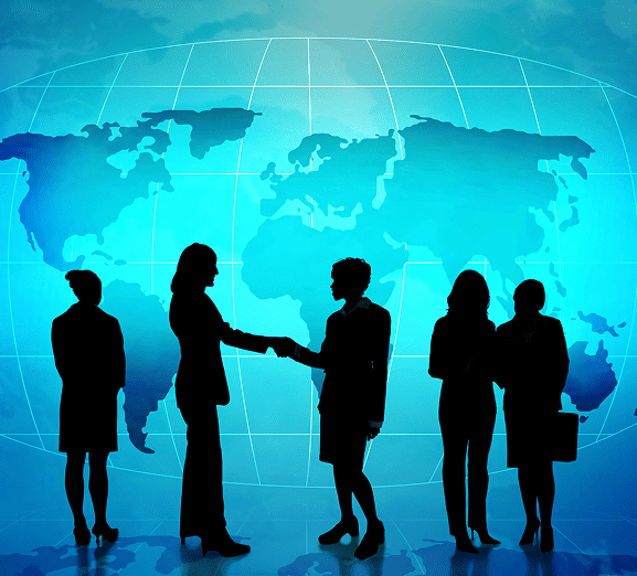 Silhouettes shaking hands in front of map.