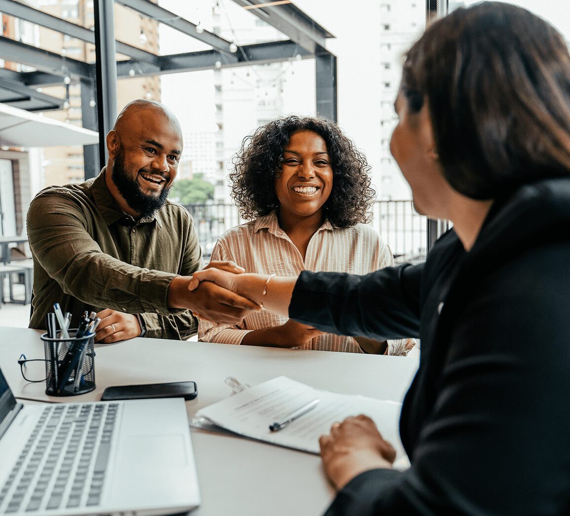 People shaking hands in a meeting.